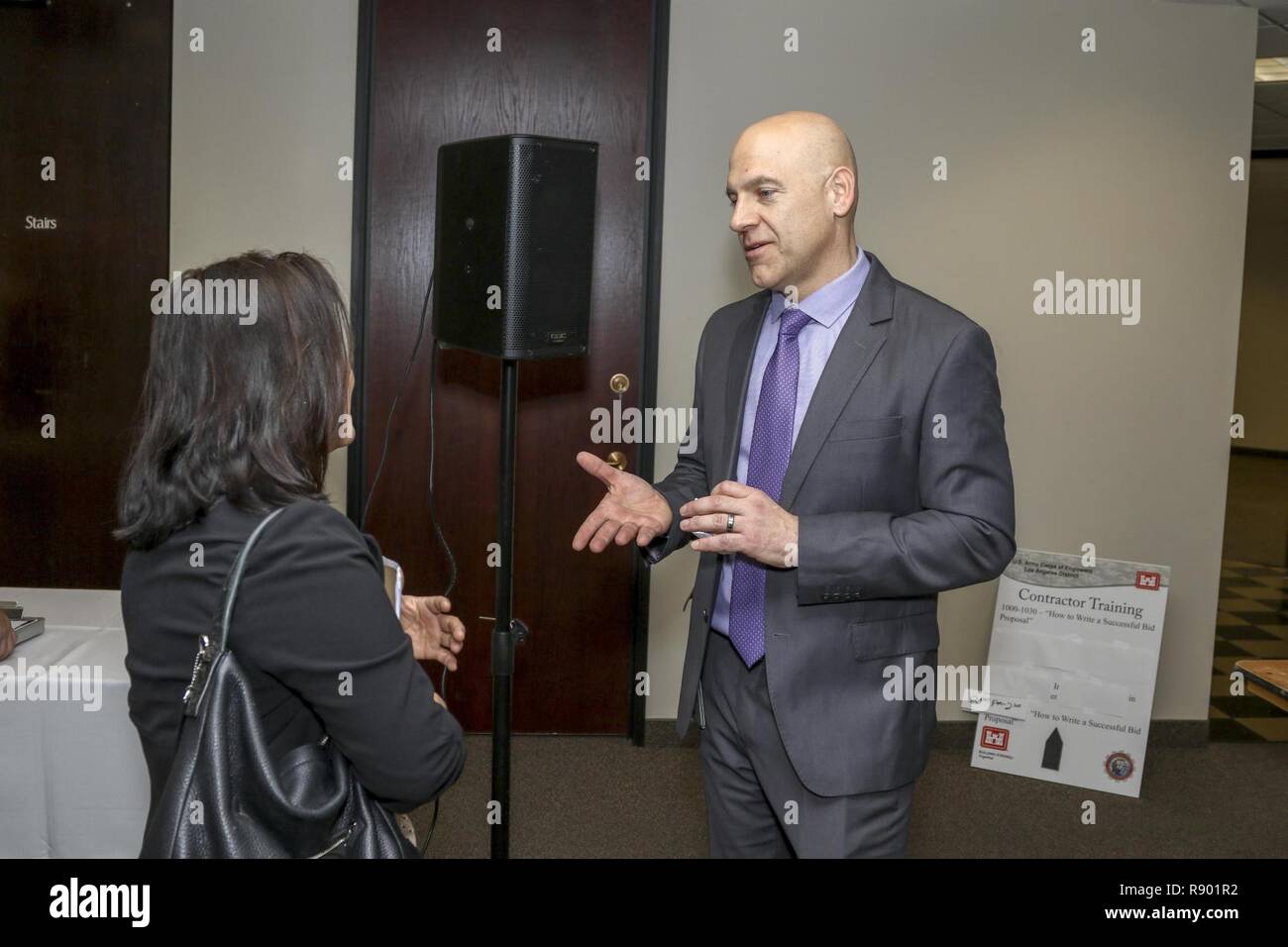 Eric Ravelli, vice per le piccole e medie imprese Programma, accoglie un partecipante al Los Angeles District Arizona-Nevada ufficio di zona di opportunità di business Open House il 9 marzo a Phoenix. L'evento ha attirato più di 160 partecipanti provenienti da tutta la regione. La open house featured mattina e pomeriggio sessioni con un appaltatore opportunità di formazione; offerta vincente proposta. Foto Stock