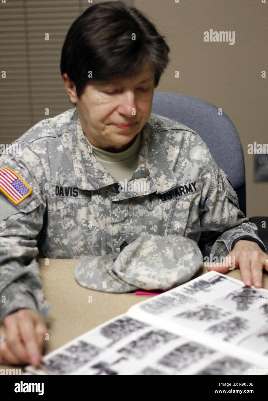 Iowa l esercito nazionale del personale di guardia Sgt. Carmen Z. Davis, di Ankeny, Iowa, servizio di assistenza Noncommissioned Officer e nastro giallo coordinatore in forze congiunte sede in Johnston, Iowa, guarda attraverso le vecchie fotografie dalla formazione di base alla fine degli anni settanta. Davis è uno dei soli tre soldati rimanenti in Iowa Guardia Nazionale che ha originariamente unite le donne del corpo d'Armata, un ramo distinto del servizio per le femmine creati durante la II Guerra Mondiale e sciolto nel 1978. Ha aderito al WAC come un campo wireman, con il compito di esecuzione di fili per comunicazioni radio, ma presto è stato trasferito ad una posizione i Foto Stock