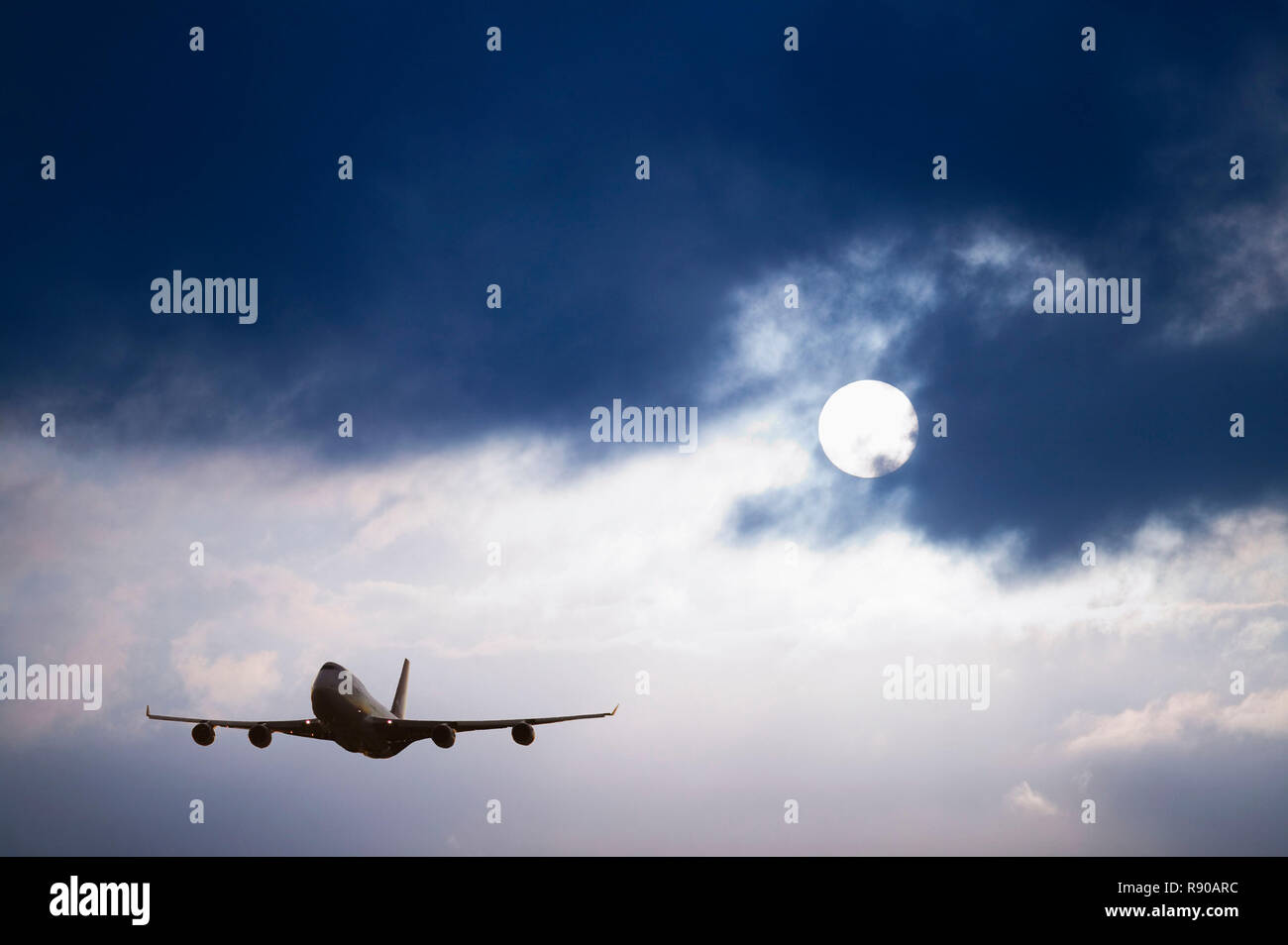 Un aeromobile in aria, silhouette contro un cielo blu scuro con la nuvola bianca. Foto Stock