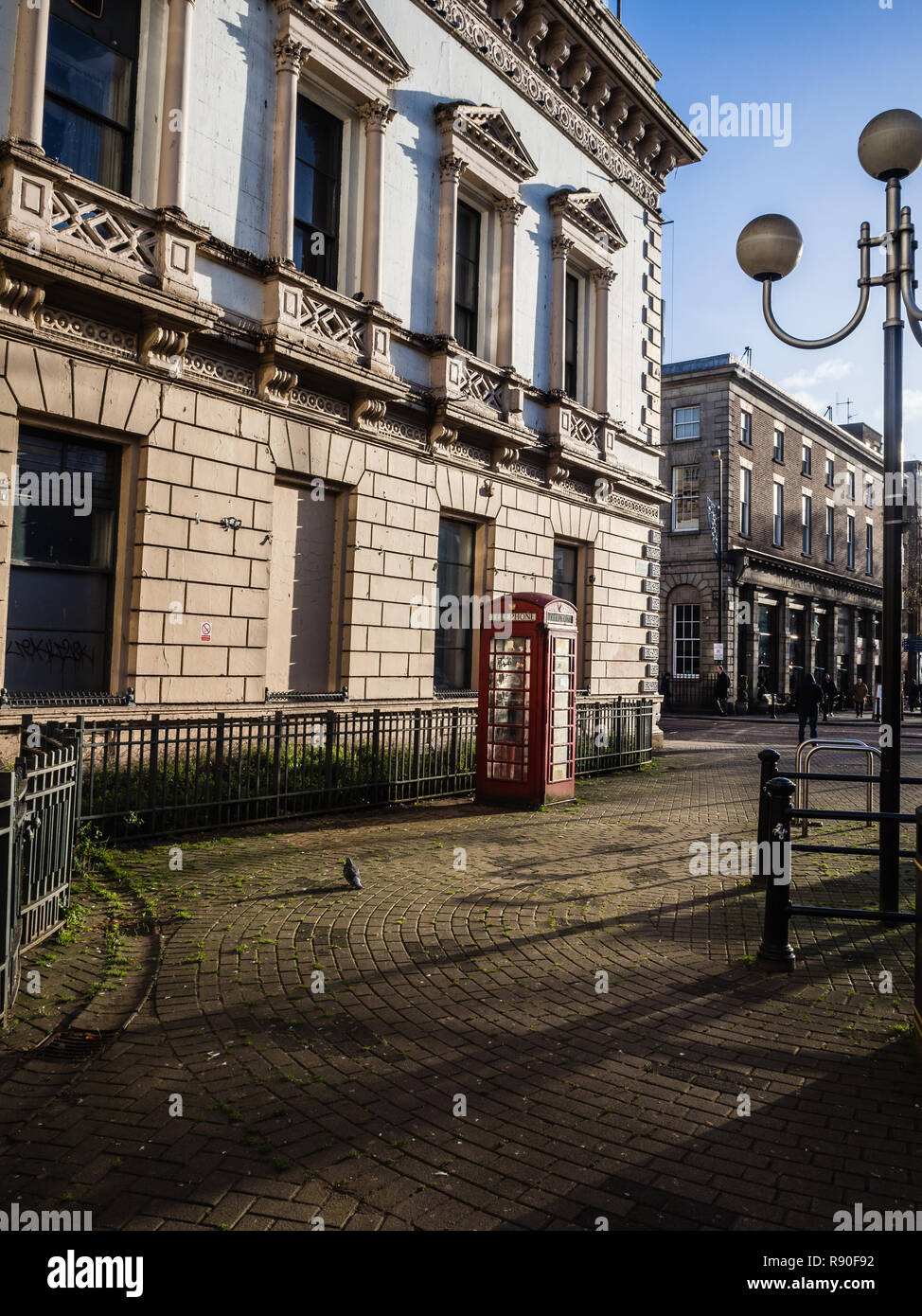 Vecchi edificio storico a Belfast con iconica telefono rosso box Foto Stock