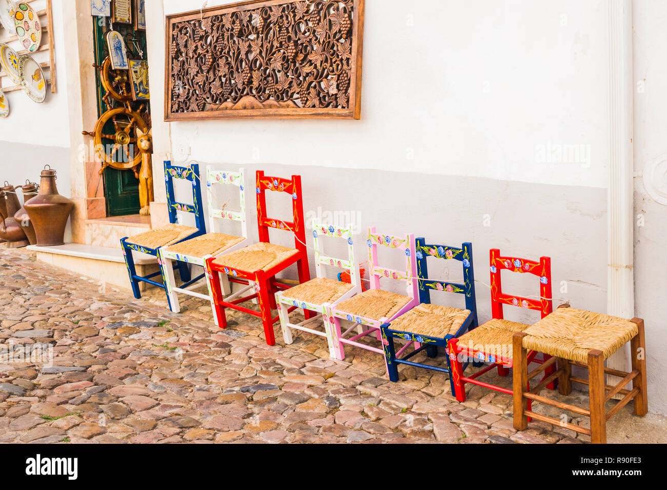 Tipici fatti a mano multicolore sedie davanti a un negozio di artigianato locale Foto Stock