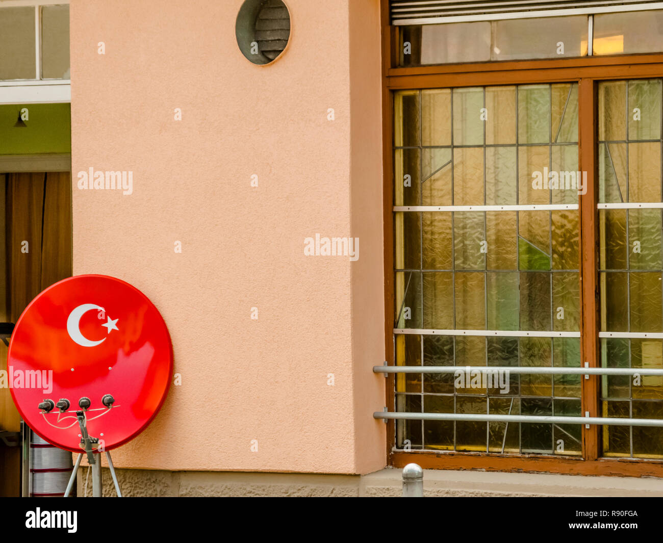 Ricevitore satellitare piatto nei colori del bagno turco bandiera nazionale di fronte ad un ristorante Foto Stock