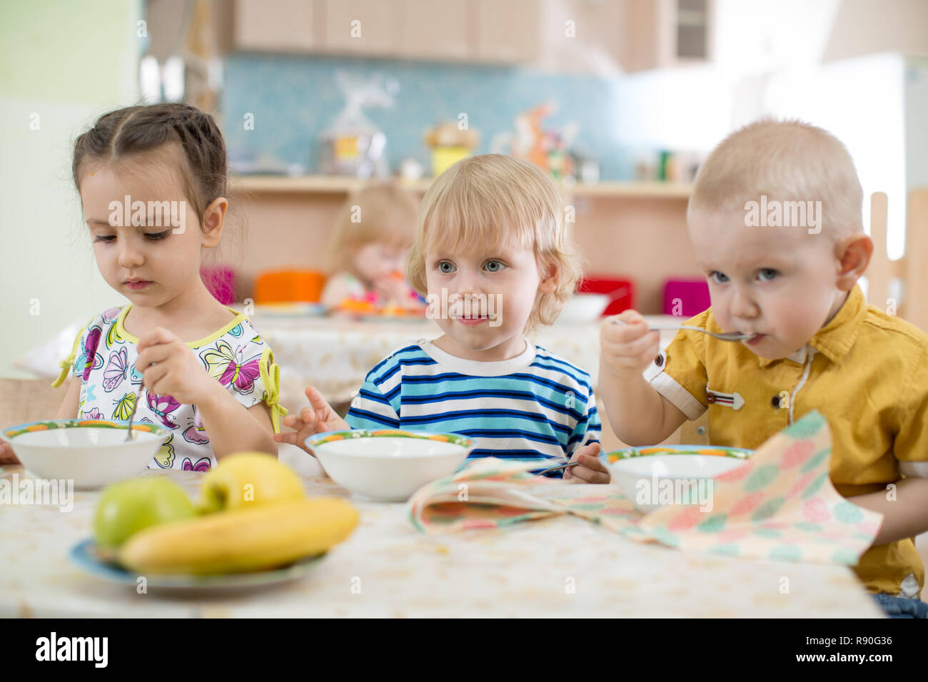 I bambini a mangiare in asilo nido o centro di assistenza Foto Stock