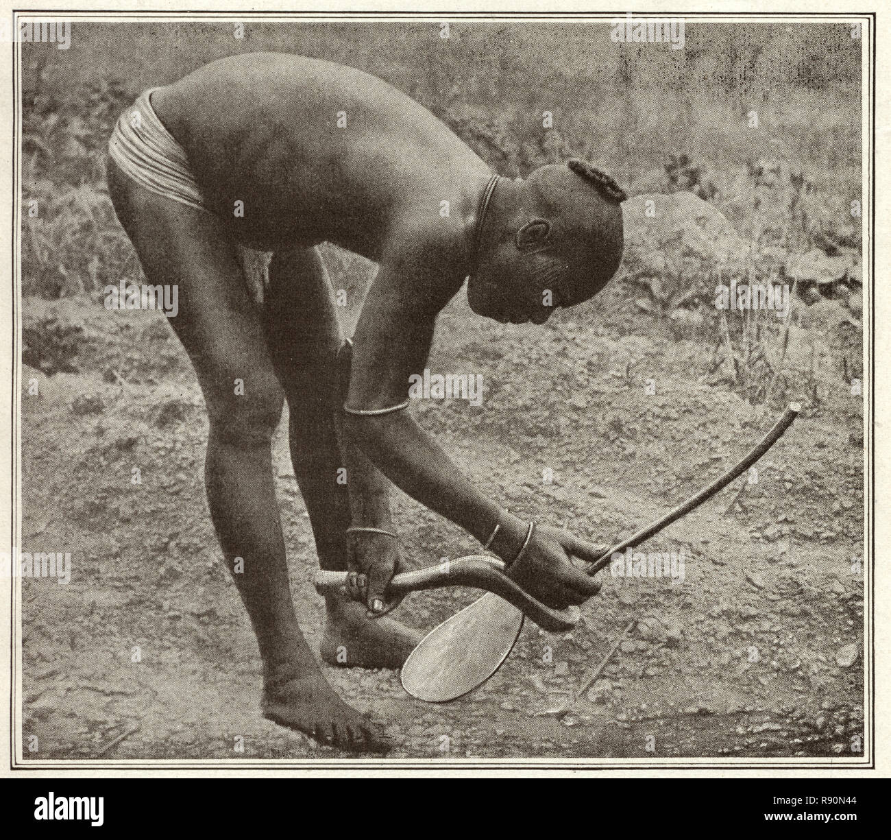 Fotografia vintage di antica agricoltura, un uomo di utilizzando una primitiva hoe. La Nigeria, nei primi anni del XX secolo Foto Stock