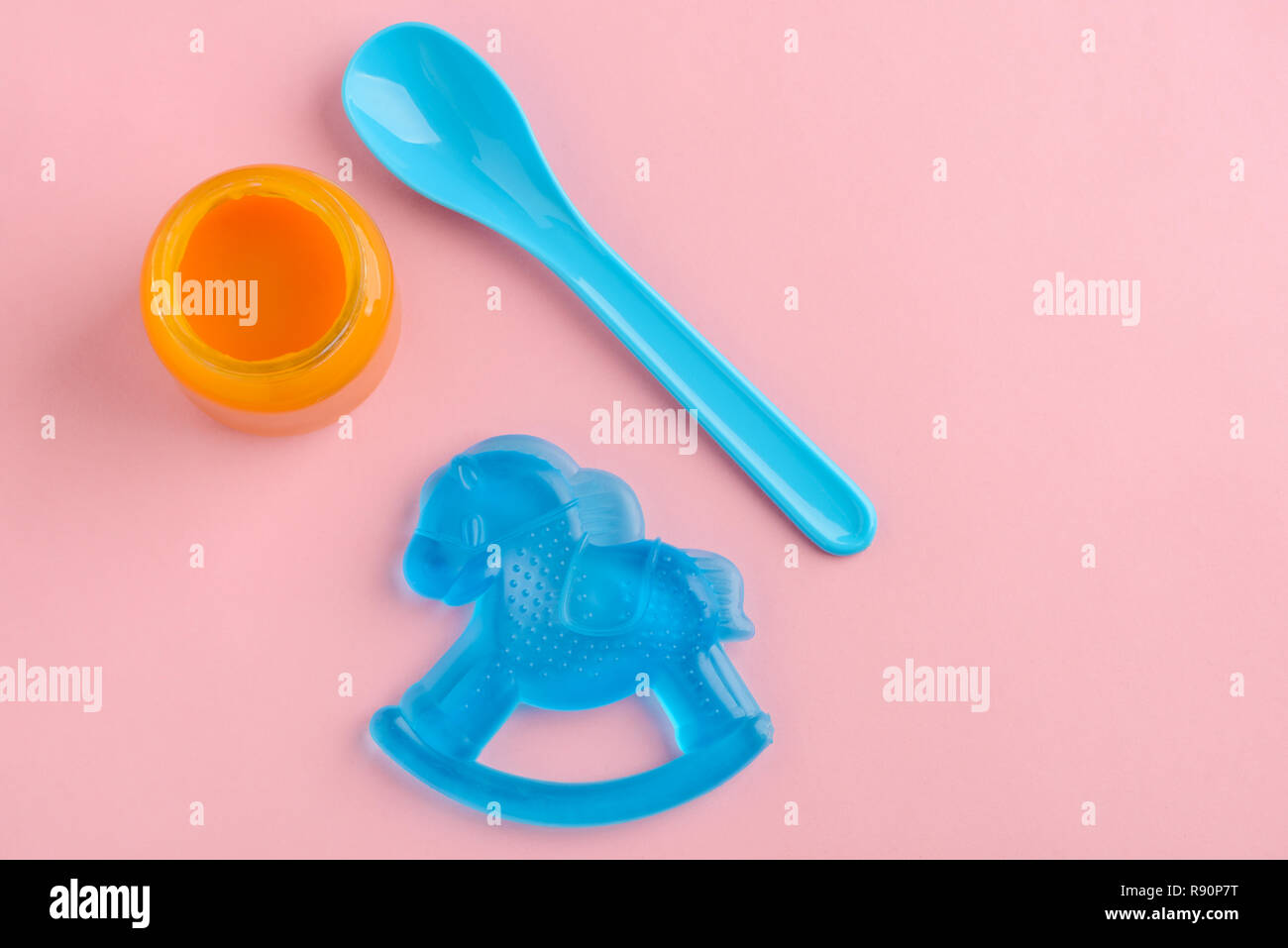 Barattolo di cibo per neonati, cucchiaio e il succhietto su sfondo rosa. Per bambini dentizione, la nutrizione e la crescita. Foto Stock