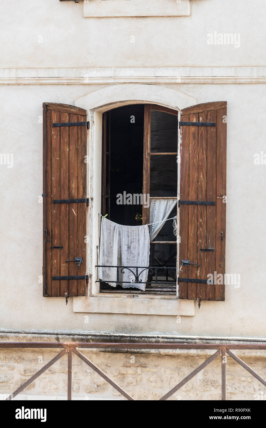 Servizio lavanderia pendente da una finestra aperta Foto Stock