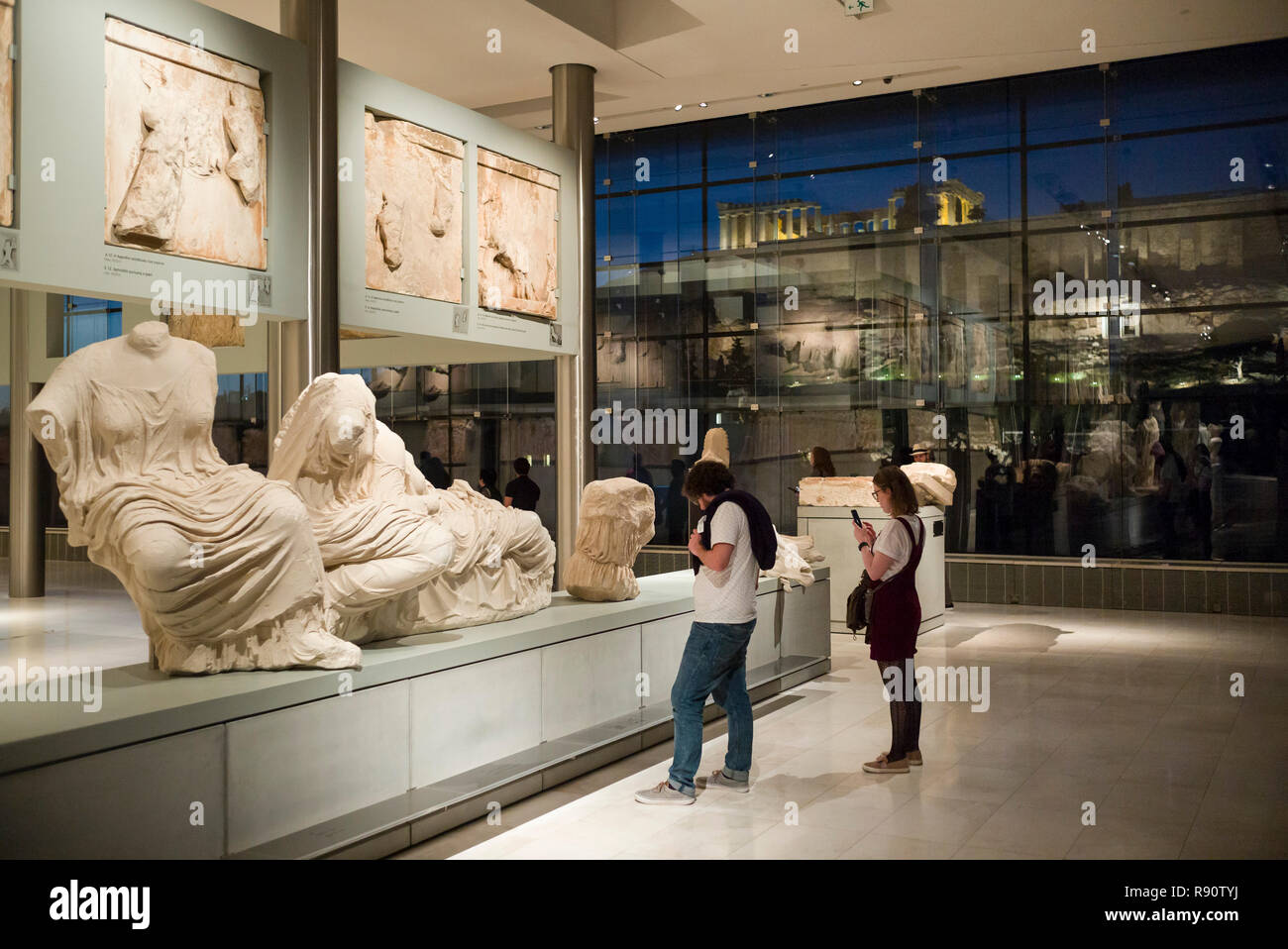 Atene. La Grecia. Interno del Museo dell'Acropoli al tramonto con il Partenone visibile in background. Mouseio Akropolis. Edificio progettato da Bernar Foto Stock