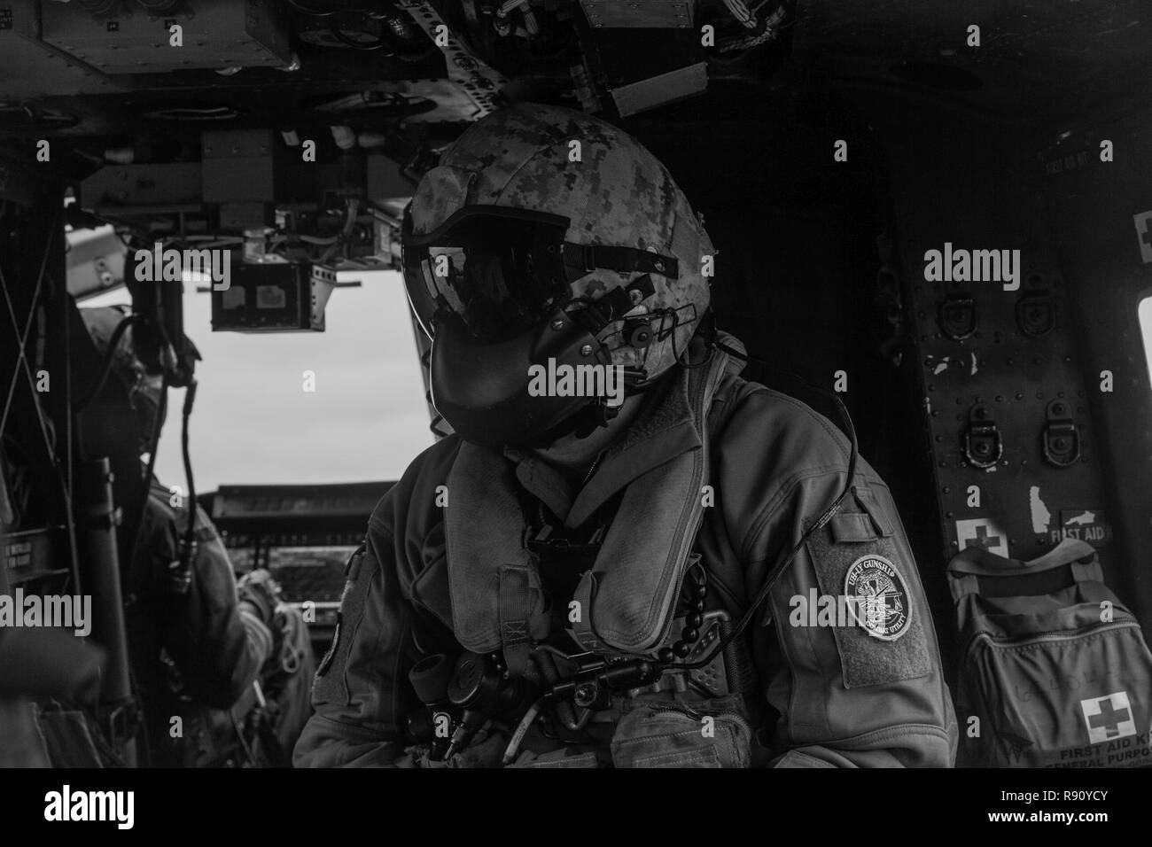 Un capo equipaggio con Marine mezzo squadrone Tiltrotor 262 (rinforzato) si siede a bordo di un UH-1Y Huey elicottero durante una simulazione di altitudine elevata, bassa apertura parachute jump e la ricognizione e la missione di sorveglianza come parte del trentunesimo Marine Expeditionary Unit MEU dell esercizio, Okinawa, in Giappone, 8 dicembre, 2018. Marines con il trentunesimo MEU Anfibio del plotone di ricognizione specializzati nella ricognizione, sorveglianza e chiudere quarti tattiche durante le operazioni anfibie. Il trentunesimo MEU, il Marine Corps' solo in modo continuo distribuita MEU, fornisce una soluzione flessibile e forza letale pronto per eseguire una vasta rang Foto Stock