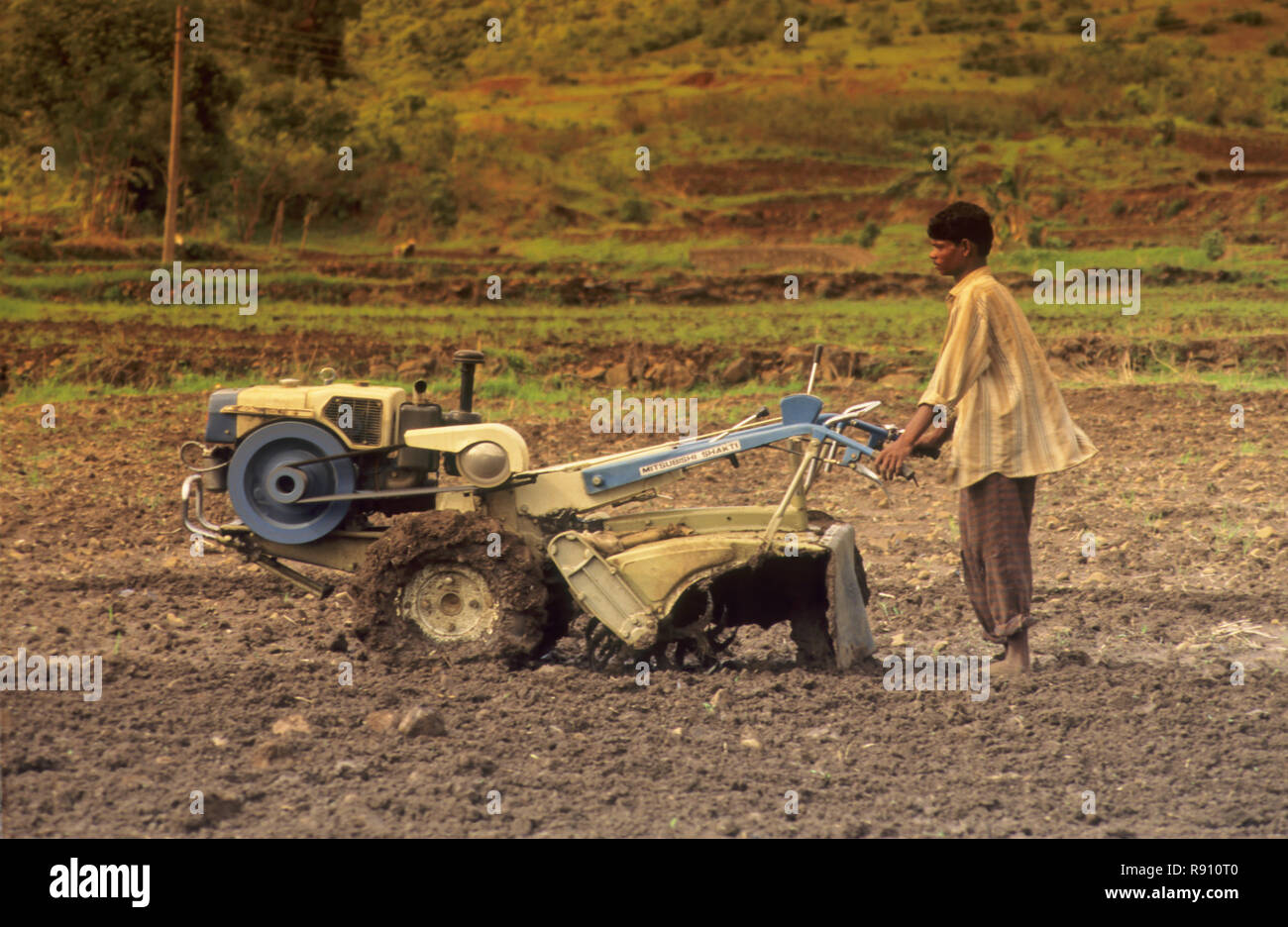 Uomo di terra agricola con la macchina, India Foto Stock