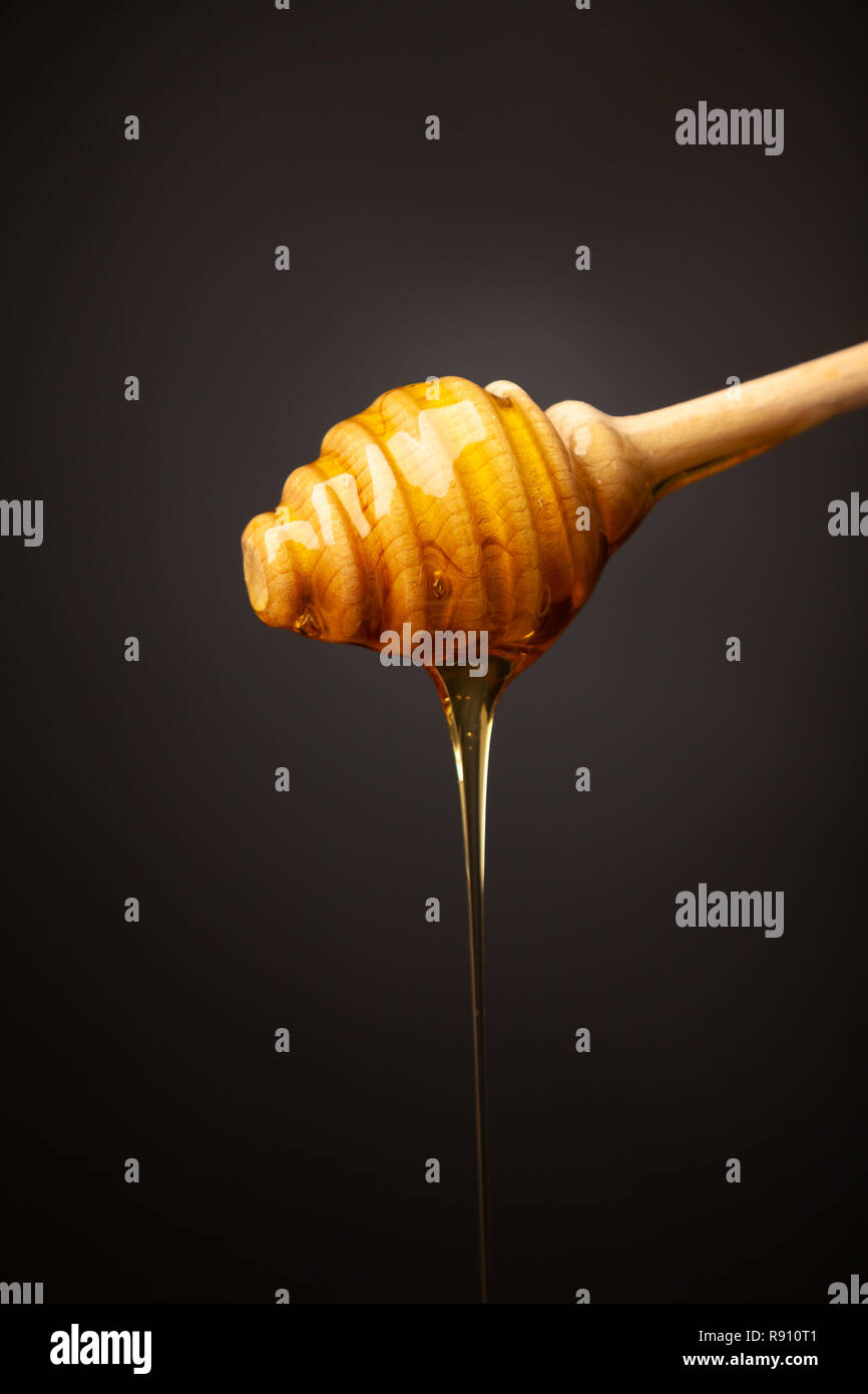 Il miele il gocciolamento da un miele di legno di bilanciere. Foto Stock