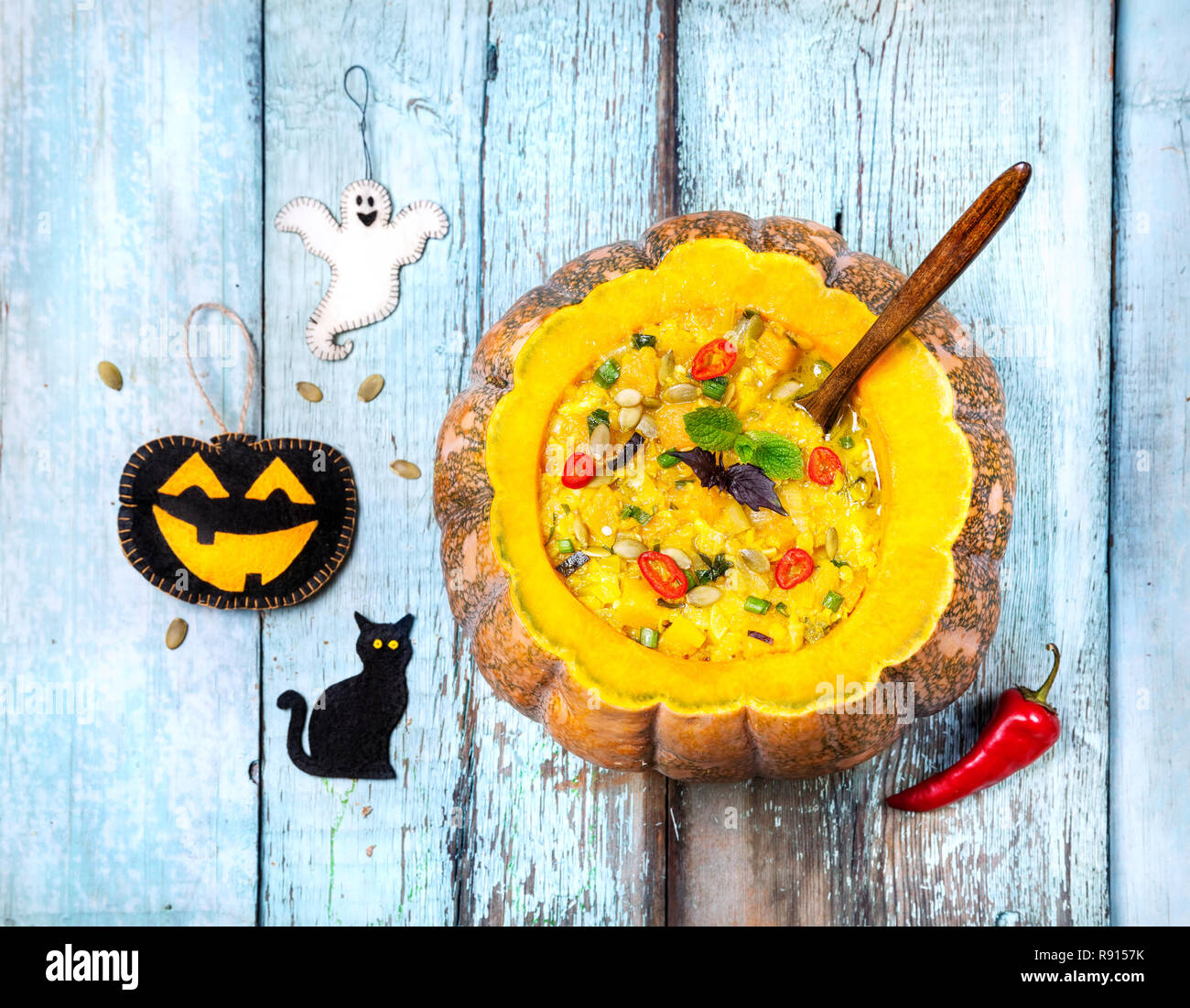 Zuppa di lenticchie con in incisa la zucca di Halloween, i giocattoli sul blu sullo sfondo di legno Foto Stock
