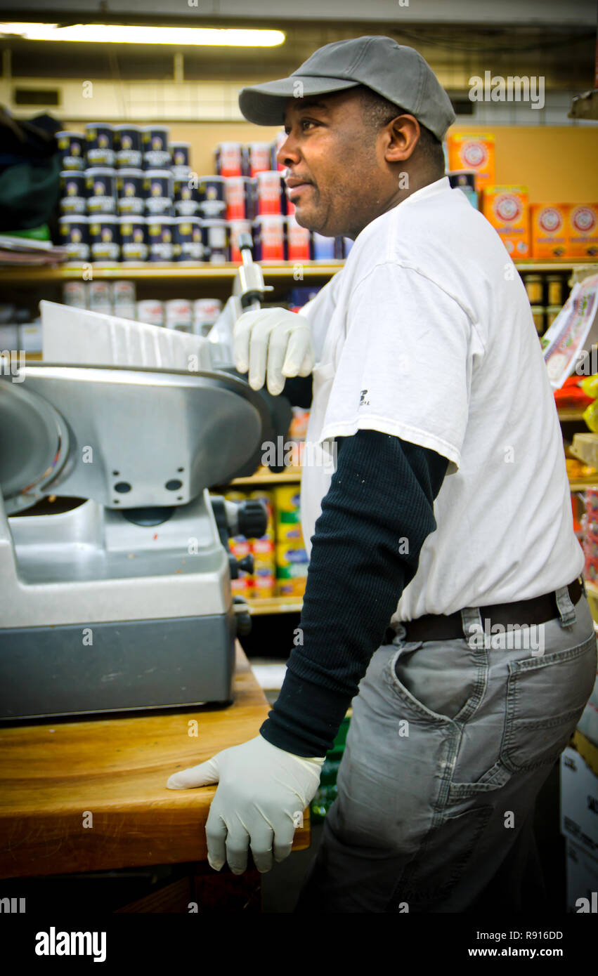 L'affettatrice di bacon Frank Moore guarda i clienti archiviare i file nel Williams Brothers General Store, 11 dicembre 2011, a Philadelphia, Mississippi. Foto Stock