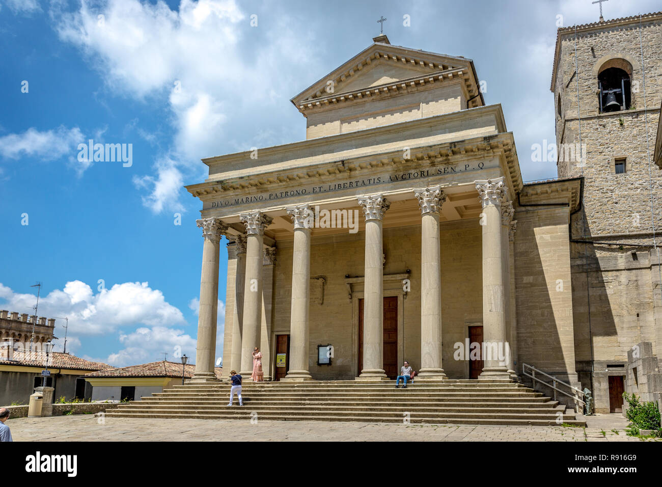 La Repubblica di San Marino, San Marino - 19 Maggio 2018 - i turisti e i locali a piedi nella parte anteriore di una chiesa di San Marino in un cielo blu giorno Foto Stock