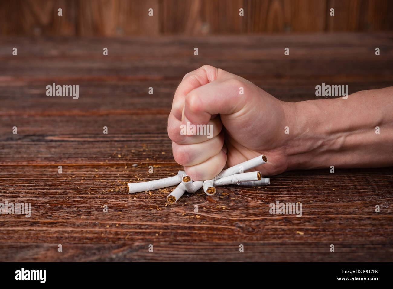 Un uomo batte il pugno sulle sigarette. Anti-fumo concetto. Foto Stock