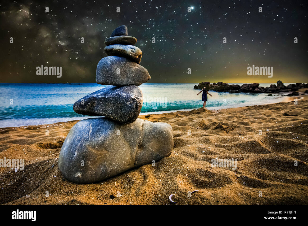 Il tumulo di pietra sulla sabbia della spiaggia, sullo sfondo della notte star paesaggio, concetto di equilibrio Foto Stock