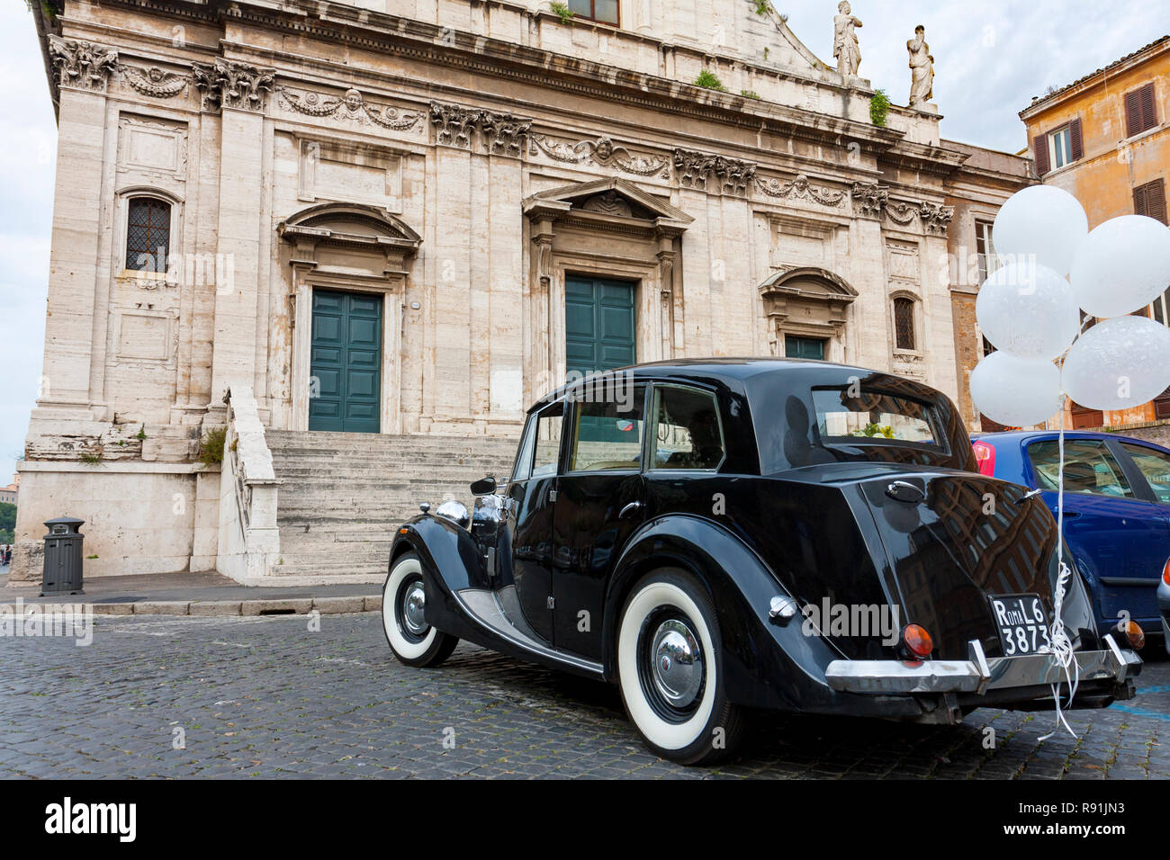Vecchia limousine nera attende per coppie in viaggio di nozze davanti alla porta di casa di Santa Maria della Consolazione chiesa, Roma, lazio, Italy Foto Stock