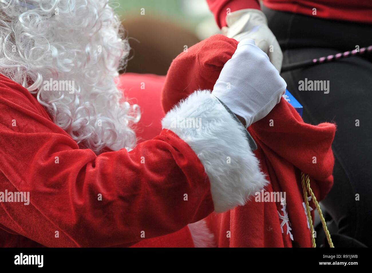 Babbo Natale, santa, dando fuori presenta. Barba bianca e guanti. Sacco rosso. Horse abstracts. 16/12/2018. Foto Stock