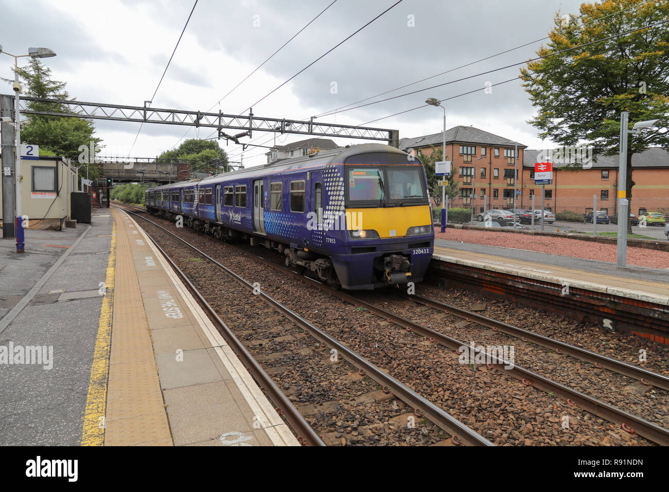 Una classe Scotrail 320 treno elettrico tirando nella piattaforma 1 di Dalmuir stazione ferroviaria Foto Stock