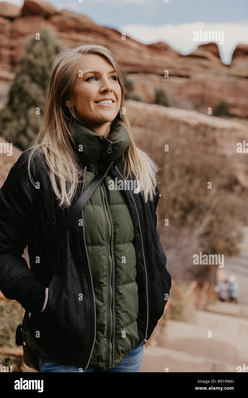 Giovani bellissimi e moderni Caucasian Donna sorridente mentre si viaggia a Red Rocks Parco in Stati Uniti al di fuori in natura presso il parco dello stato Foto Stock