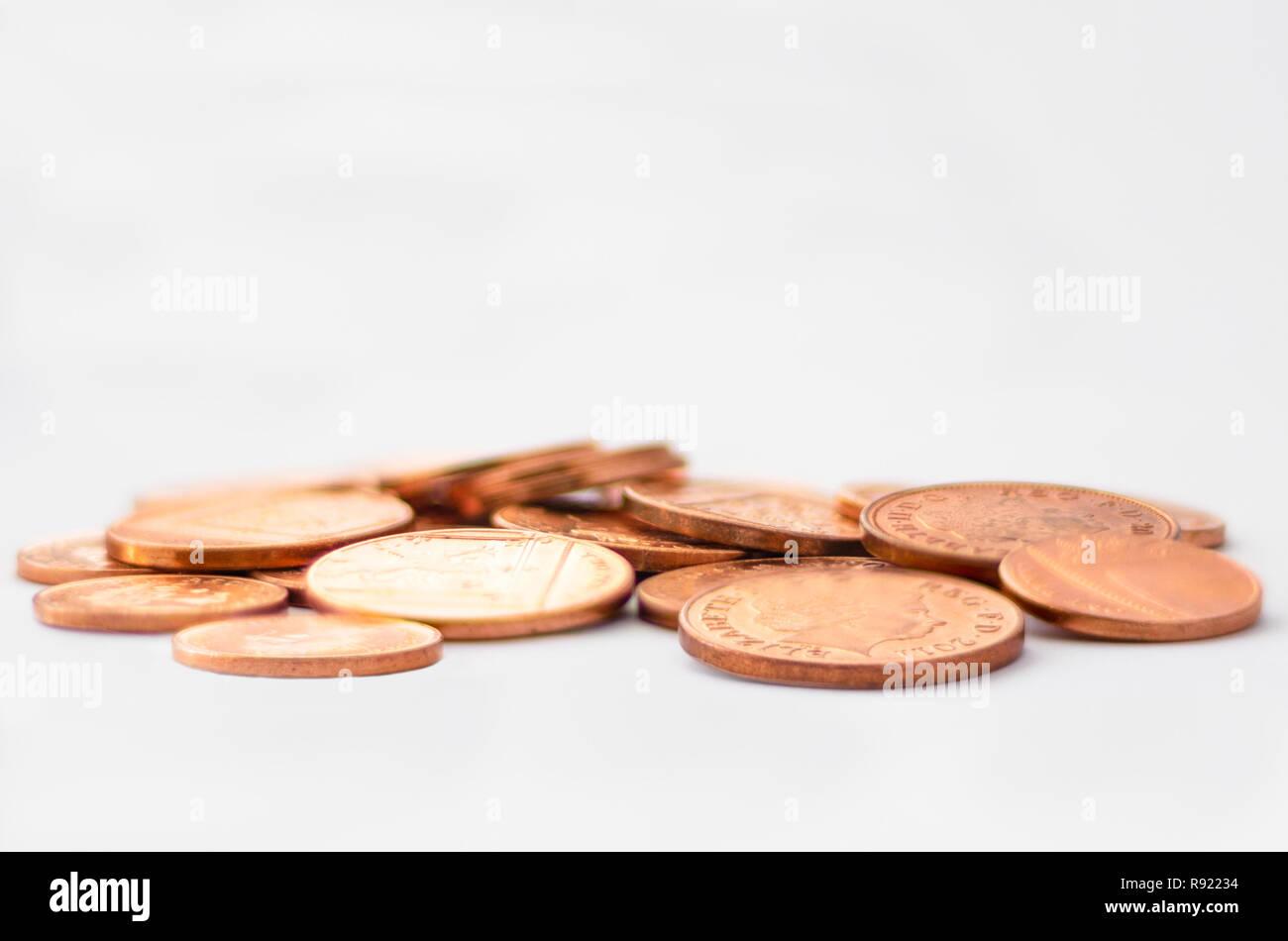 Manciata di GBP valuta britannica Penny monete indicate sulla parte superiore di sfondo bianco con spazio vuoto Foto Stock