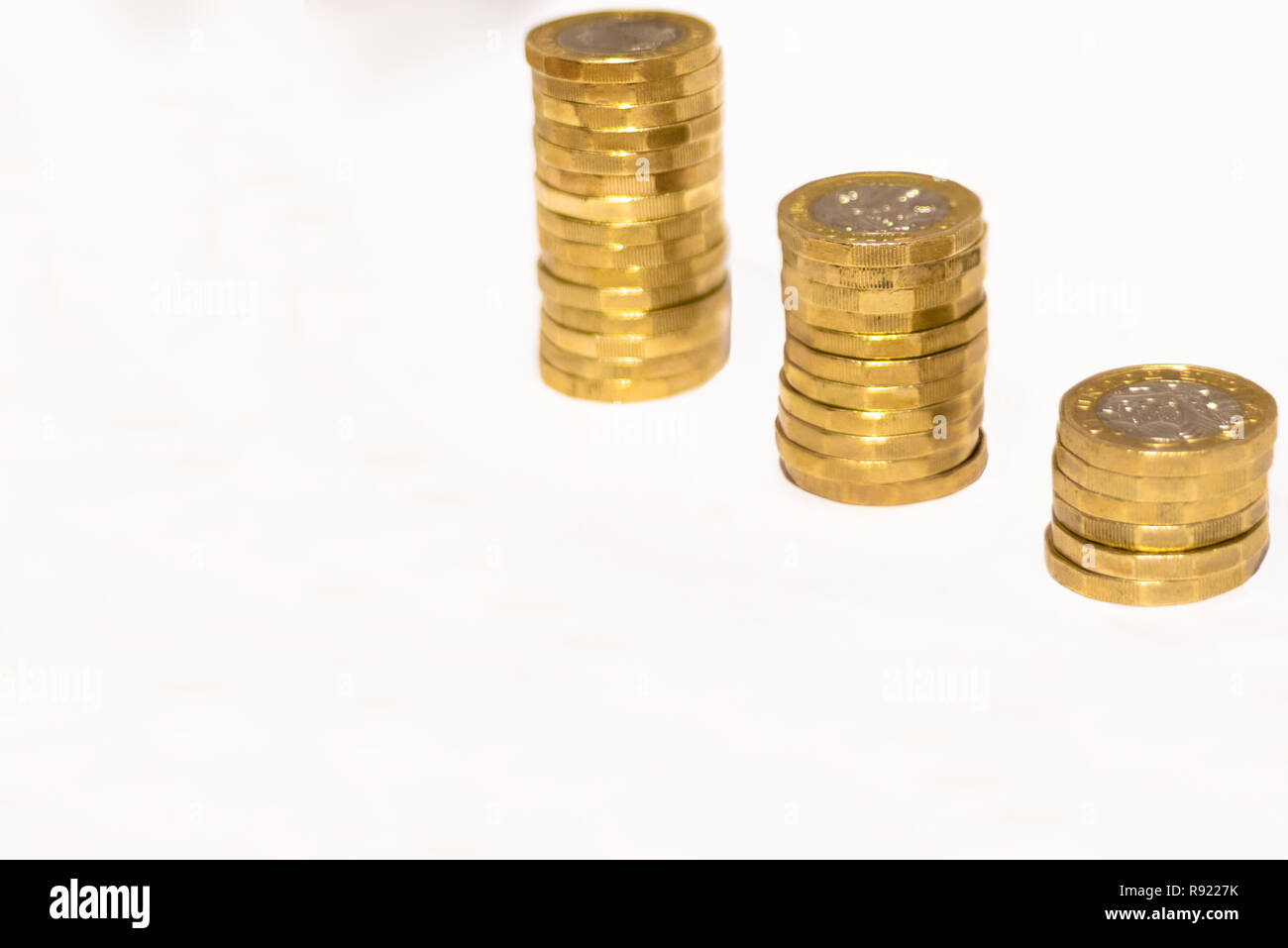 Pile e cumuli di British GBP monete doro Moneta soldi su sfondo bianco con spazio vuoto Foto Stock