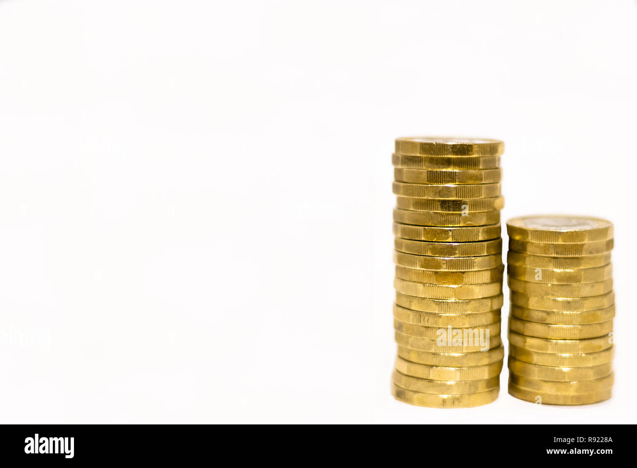 Pile e cumuli di British GBP monete doro Moneta soldi su sfondo bianco con spazio vuoto Foto Stock