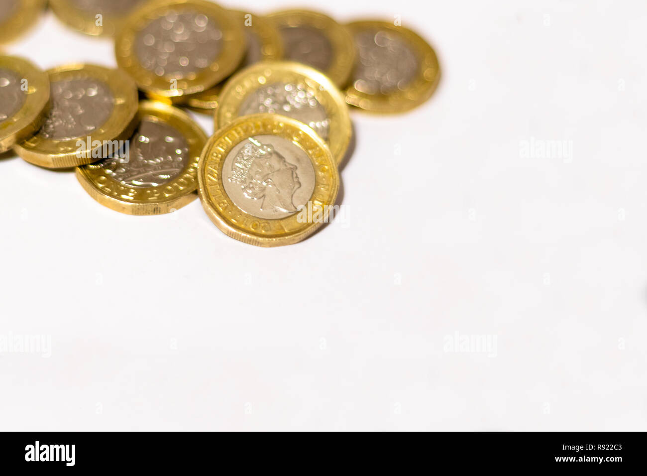 Pile e cumuli di British GBP monete doro Moneta soldi su sfondo bianco con spazio vuoto Foto Stock