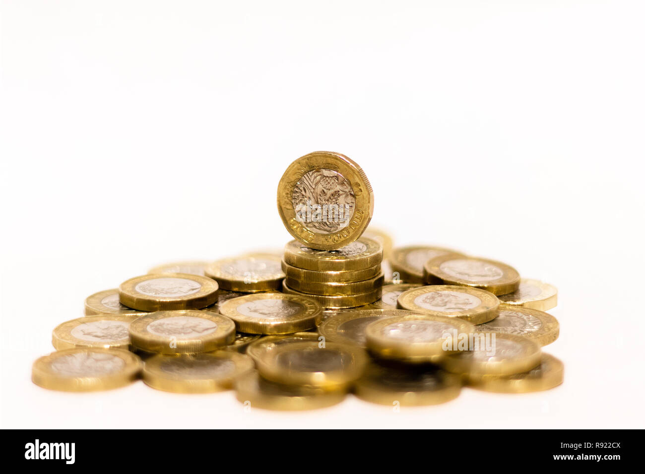 Pile e cumuli di British GBP monete doro Moneta soldi su sfondo bianco con spazio vuoto Foto Stock