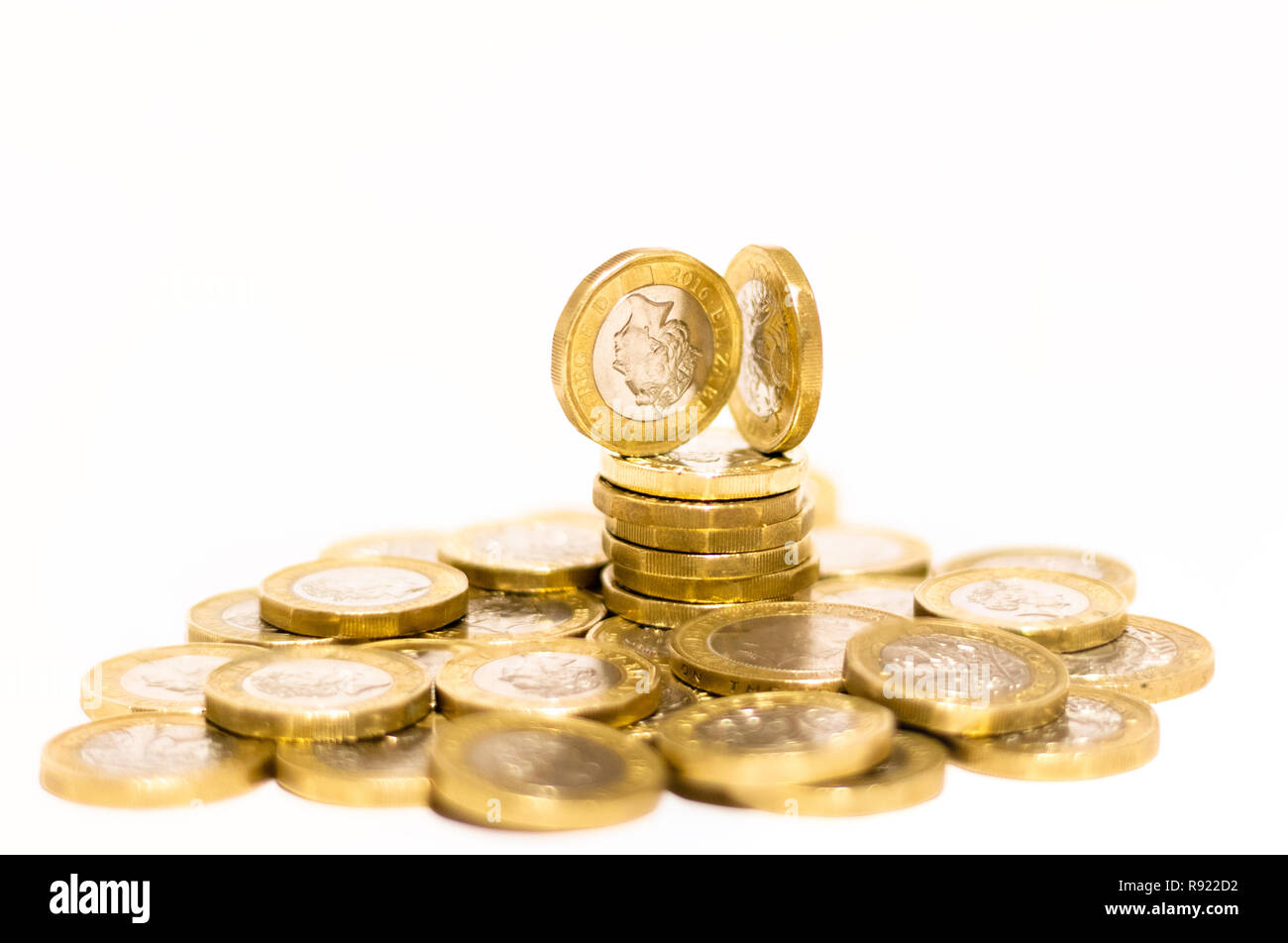 Pile e cumuli di British GBP monete doro Moneta soldi su sfondo bianco con spazio vuoto Foto Stock