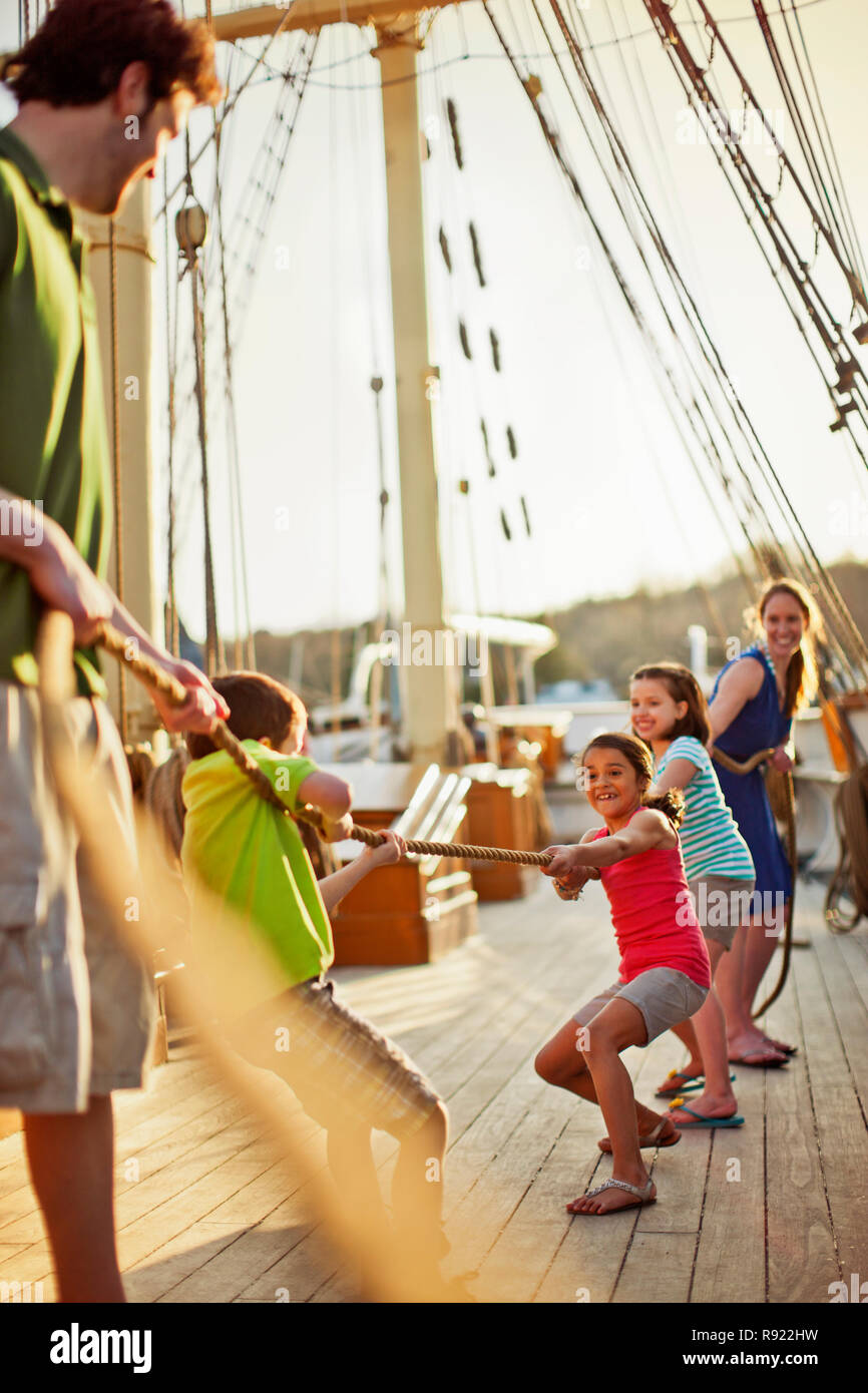 Famiglia giocando rimorchiatore di guerra sul ponte della nave. Foto Stock