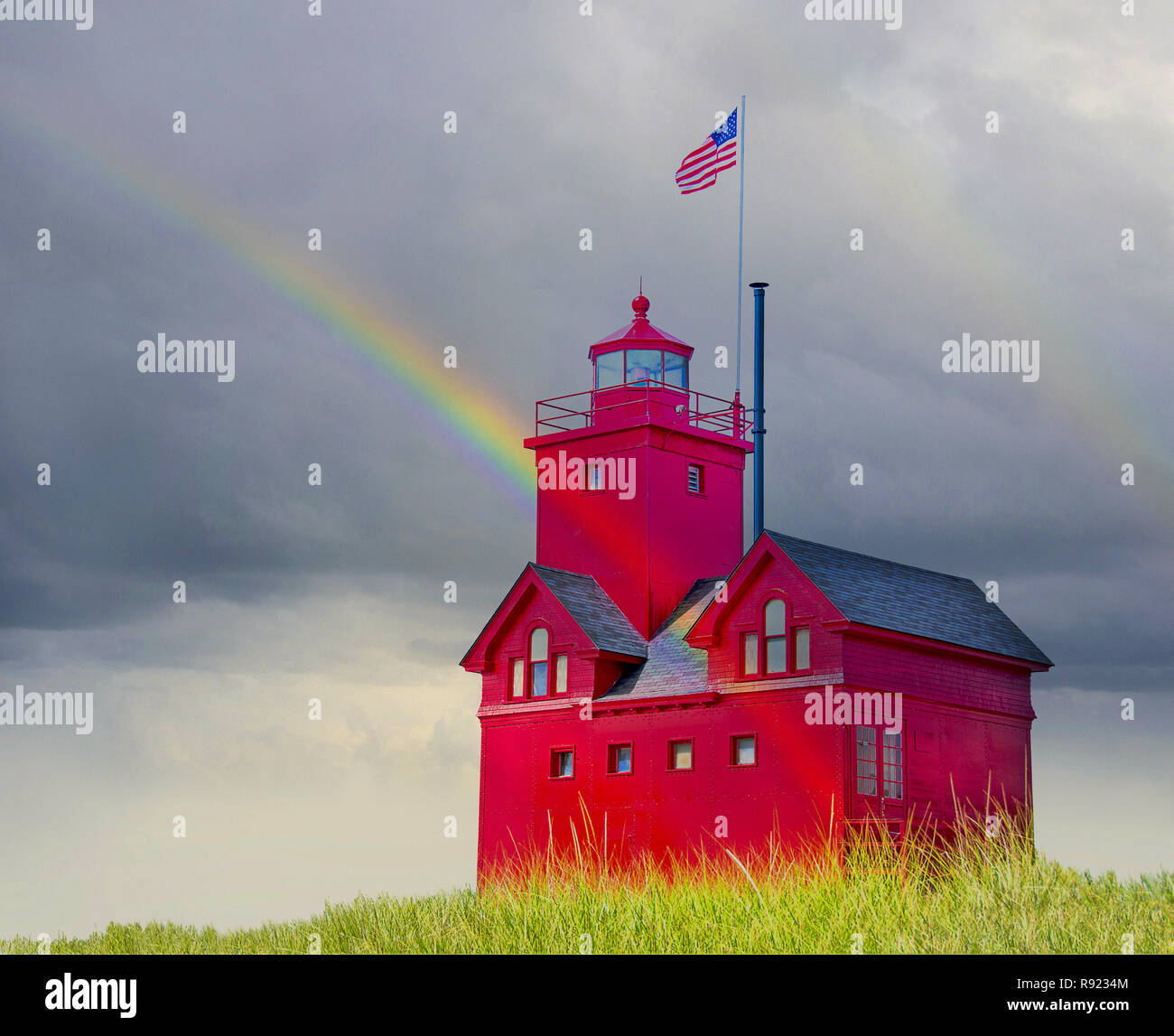 Michigan faro rosso in erba di dune con arcobaleno e nuvole di tempesta Foto Stock