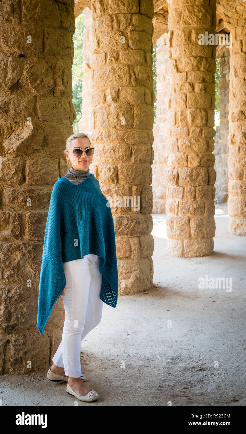 La donna a piedi attraverso un colonnato nel Parco Guell di Barcellona Foto Stock