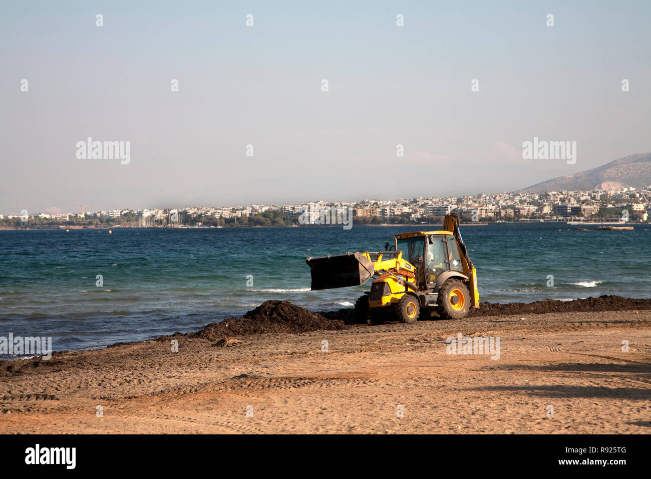 Jcb escavatore meccanico di clearing spiaggia kavouri vouliagmeni Atene Attica Grecia Foto Stock