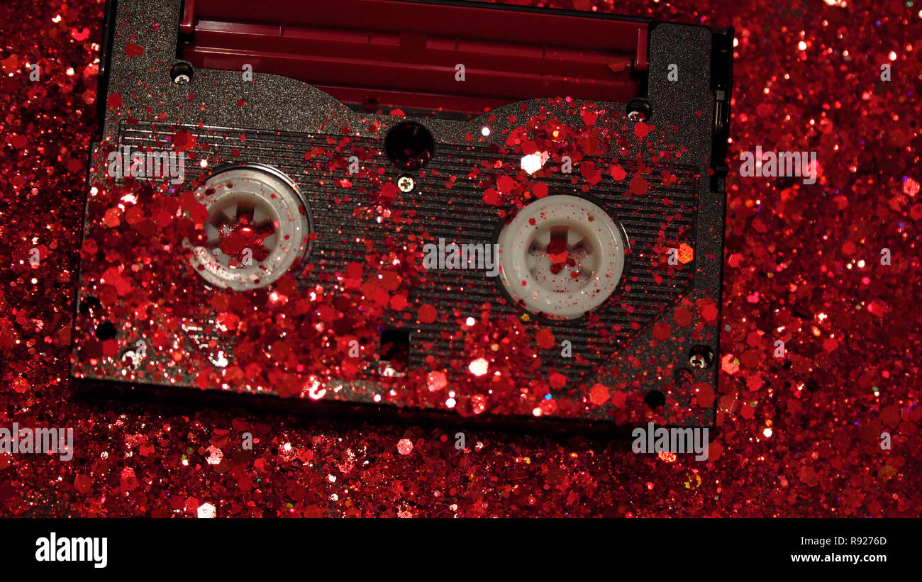 Nero cassetta video sullo sfondo di rosso glitter Foto Stock
