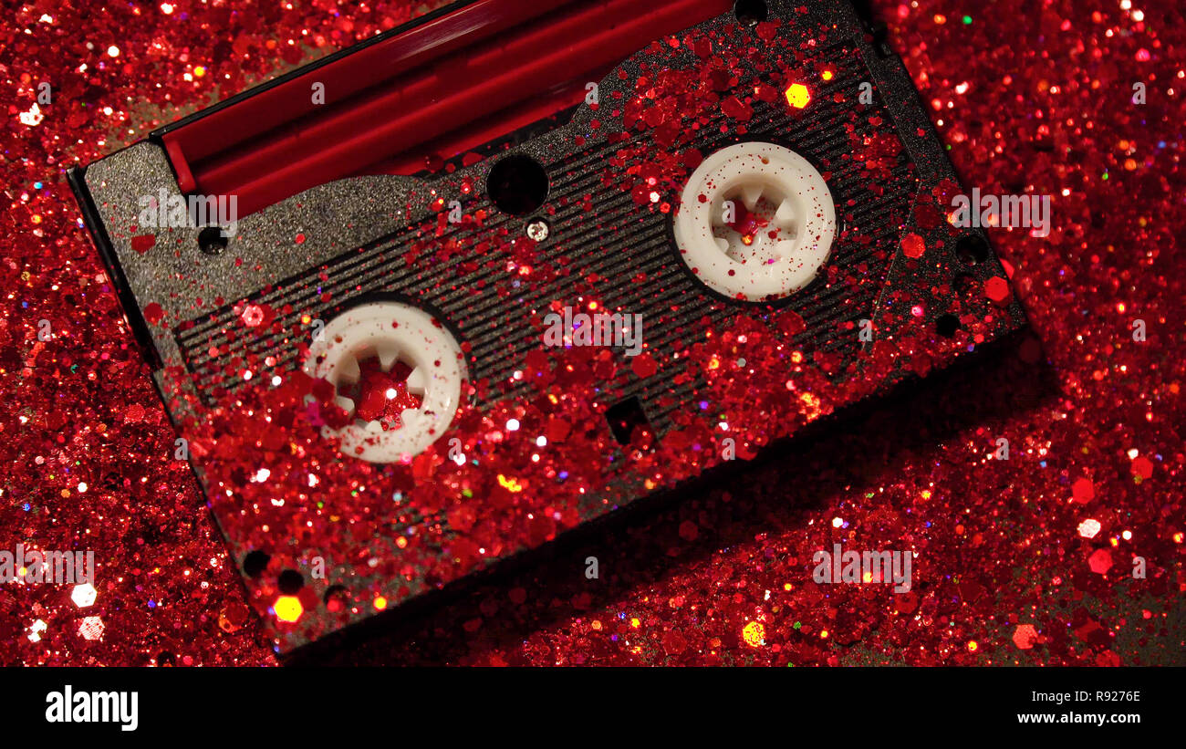 Nero cassetta video sullo sfondo di rosso glitter Foto Stock