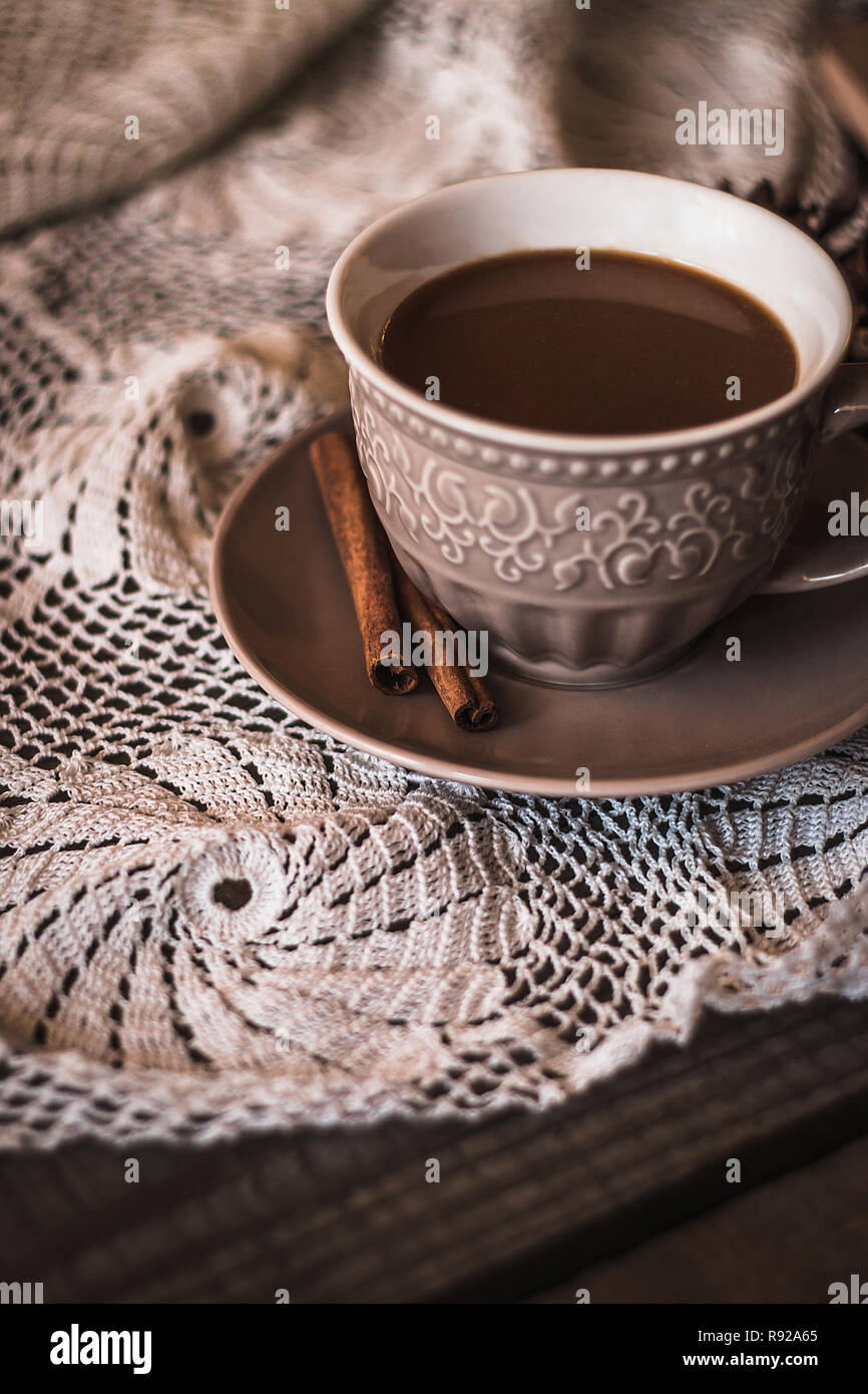 Caffè in grani tostati con bastoncini di cannella in tazza di ceramica  bianca sfondo blu Foto stock - Alamy