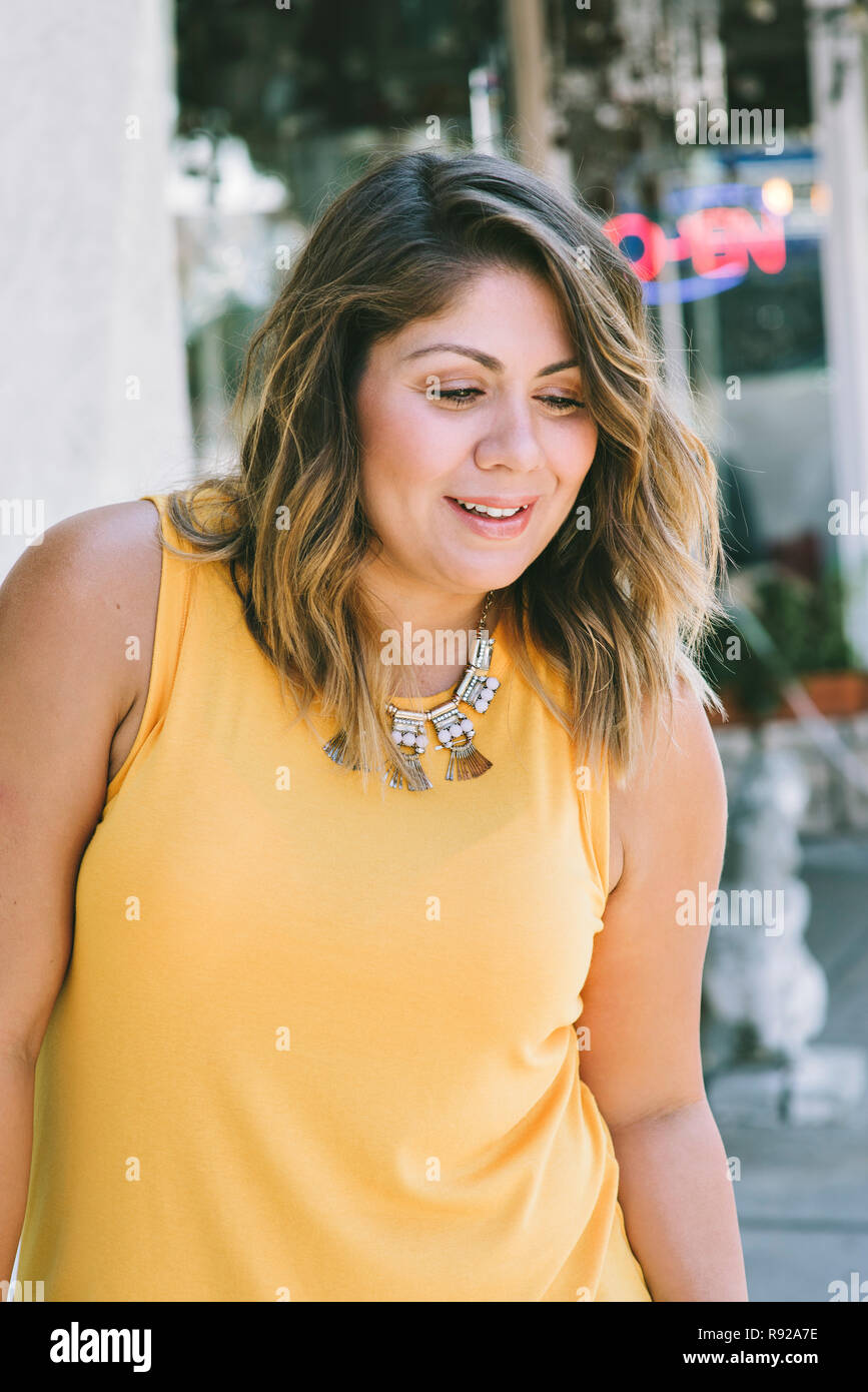 Giovane latina blogger pone con un grande sorriso in un posizione urbana Foto Stock