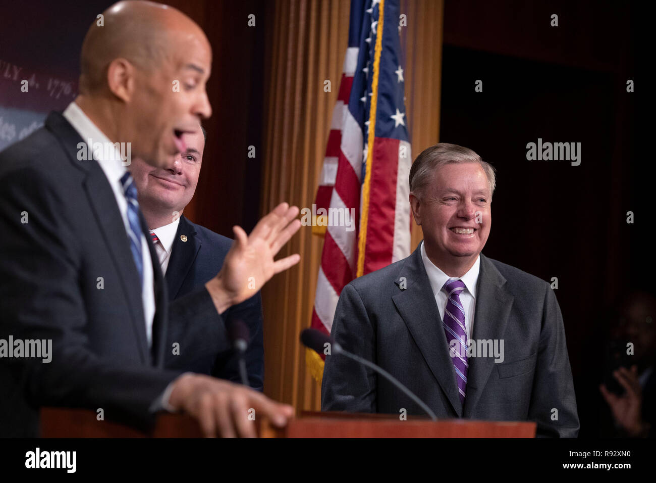 Il senatore Lindsey Graham, il repubblicano della Carolina del Sud, sorrisi come senatore Cory Booker, democratico del New Jersey, parla nel corso di una conferenza stampa per celebrare il passaggio della prima fase atto agli Stati Uniti Campidoglio di Washington il 19 dicembre 2018. Credito: Alex Edelman/CNP /MediaPunch Foto Stock