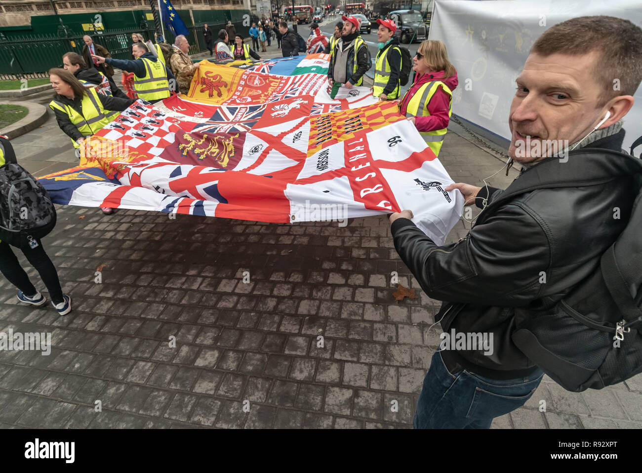 Londra, Regno Unito. 19 dicembre 2018. Un piccolo gruppo di estrema destra pro-Brexit manifestanti unfrul un grande striscione che mostra loro ot essere Arsenal sostenitori. Essi vennero a gridare e sostengono con il quotidiano SODEM (Stand di Defiance Movimento Europeo) contestatori e a gridare insulti personali al Steven Bray che fondarono SODEM nel settembre 2017. La polizia ha cercato di mantenere gli scontri, pacifica e ha avvertito la destra manifestanti circa la loro lingua. Il Brexiteers poi accusato la polizia di tenendo i lati. Alla fine essi allontanati per protestare al di fuori del Parlamento. Peter Marshall / Alamy Live News Foto Stock