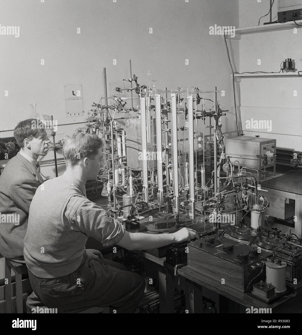 1948, storico, all'interno di un laboratorio scientifico all'Università di Oxford, Oxford, Inghilterra, Regno Unito,...... due studenti di ricerca scientifica conducono esperimenti con uno strumento di misurazione dell'epoca, un potenziometro, un divisore di tensione utilizzato per misurare il potenziale elettrico o la tensione. Foto Stock