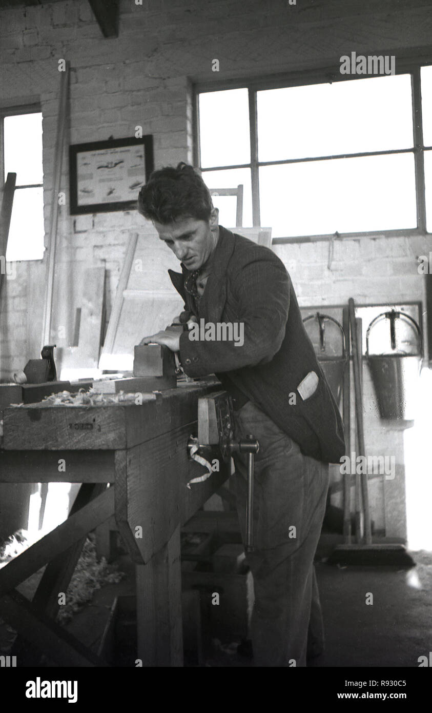 1940s, storico, un ex minatore ri-impiegati facendo lavori in metallo in un workshop, Wales, Regno Unito. Foto Stock