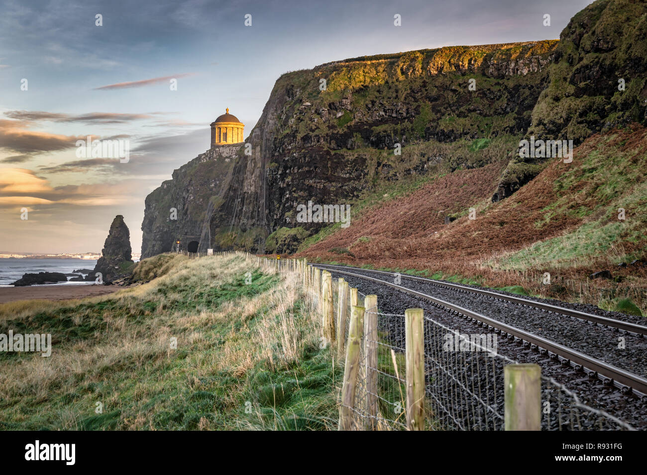Questa è una foto della railtracks che corrono lungo la costa di Antrim. In lontananza si possono vedere Mussenden Temple sul bordo della scogliera Foto Stock