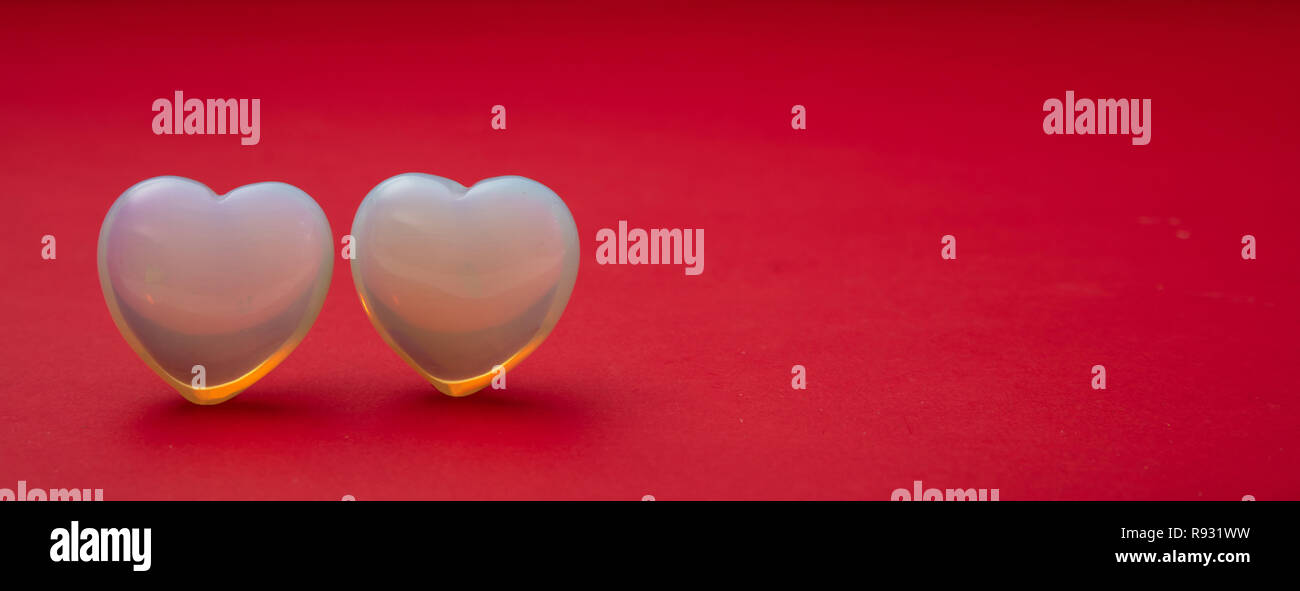 Il giorno di San Valentino. Vista superiore della luce blu cuori di vetro su sfondo rosso, banner, spazio di copia Foto Stock