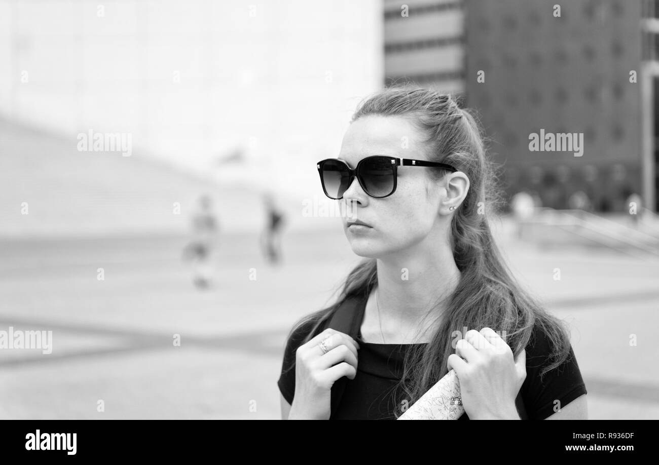 Ragazza occhiali da sole turistica godono di vista piazza di Parigi centro citta'. La donna a stare di fronte di architettura urbana spazio copia. Deve visitare place. Guida per il turista alla scoperta di Parigi. Backpacker esplorare la città. Foto Stock