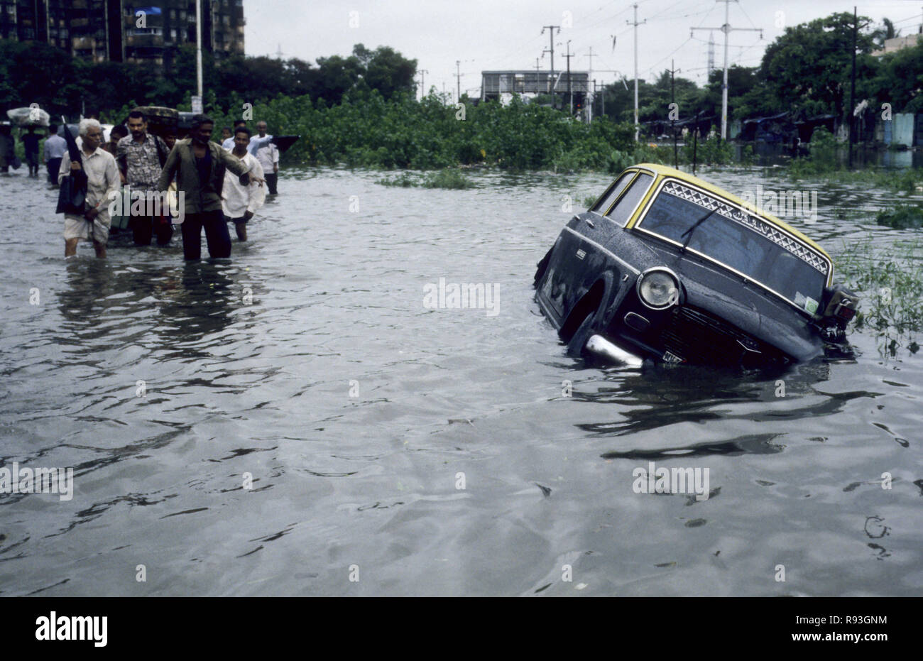 Taxi sommerso dalle inondazioni di acqua piovana per strada nella stagione dei monsoni Bombay Mumbai Maharashtra India monsone indiano Asia Asia Asiatica Foto Stock