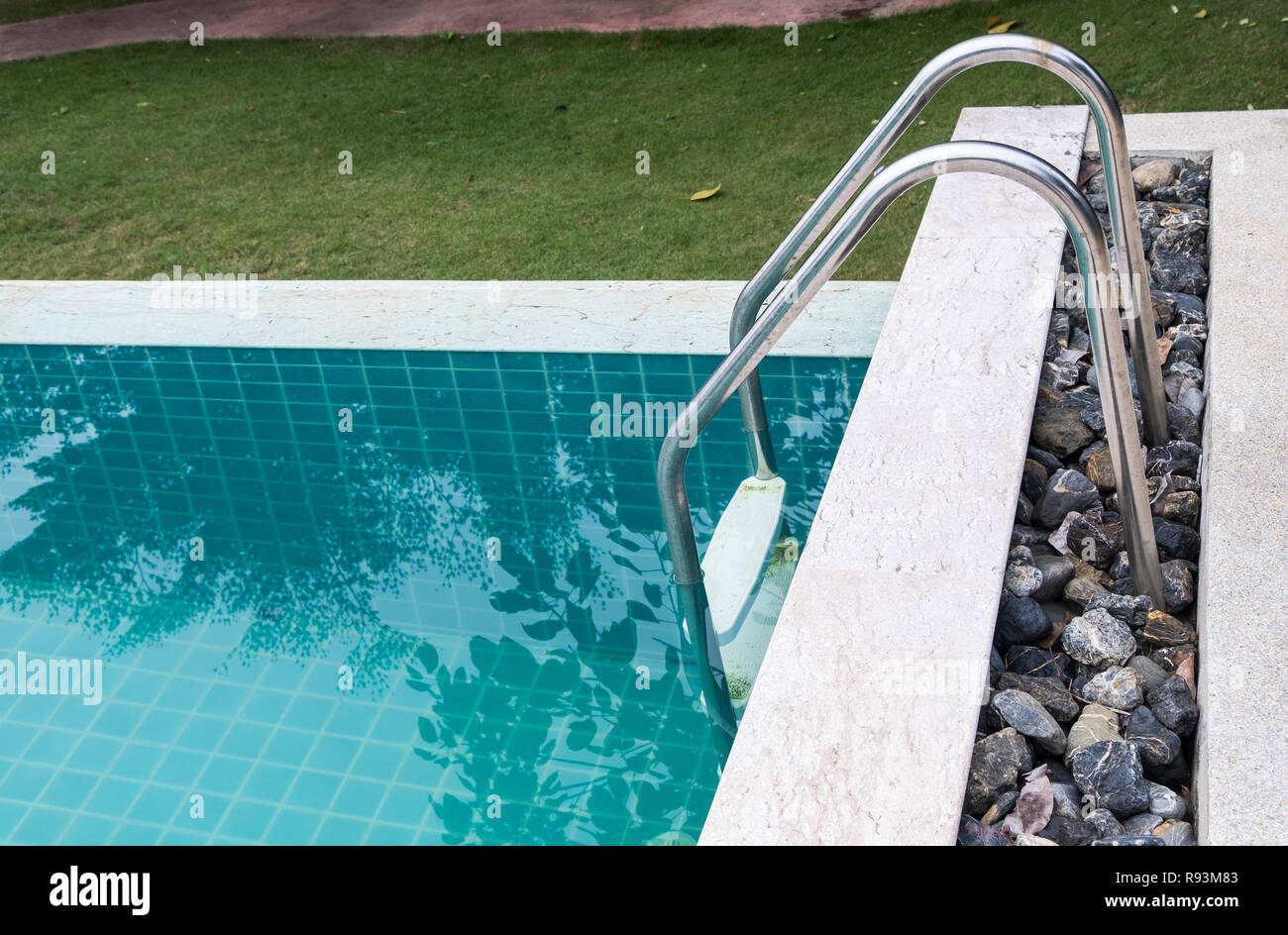 Rotaia metallica della scala in chiaro piscina in hotel tropicale e. Foto Stock