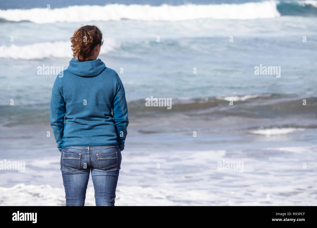Vista posteriore della donna che guarda al mare Foto Stock