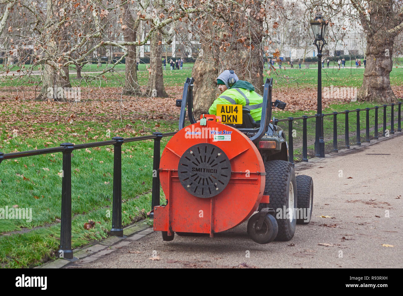 London, Westminster. Un operaio di soffiaggio foglie morto in un modo più gestibile raccolta dalla regina della passeggiata nel verde parco. Foto Stock