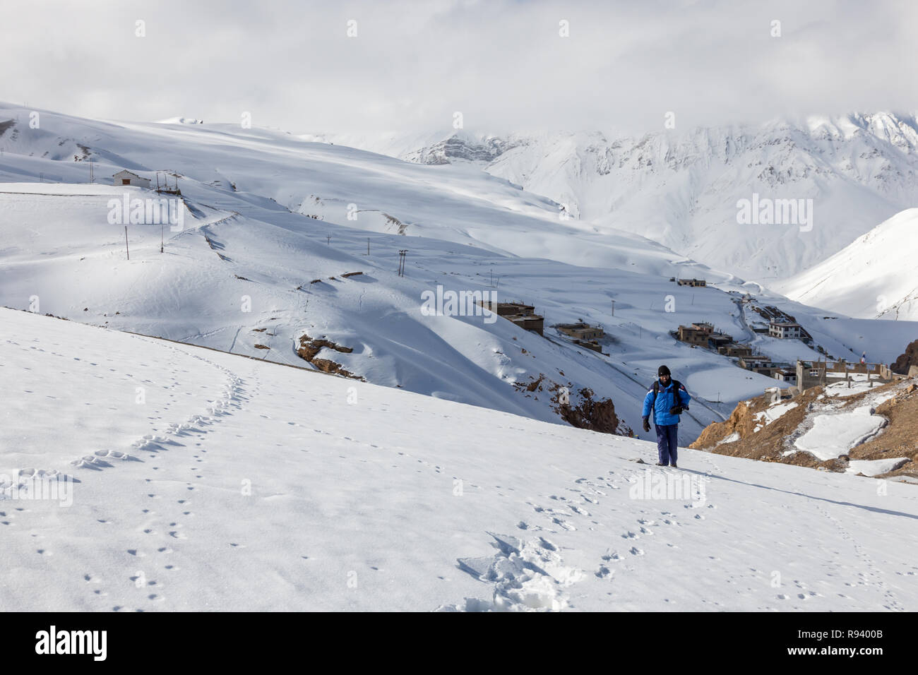 Un Trekker passeggiate nella neve pesante al villaggio di Kibber in Spiti Valley in cerca di Snow Leopard durante il periodo invernale in Himalaya. Foto Stock