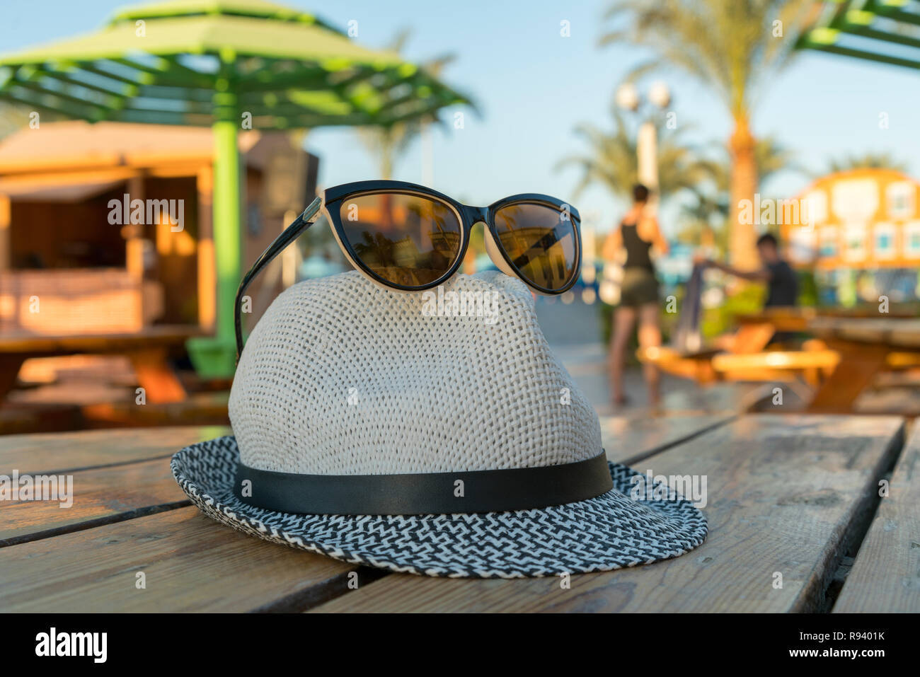 Occhiali da sole e cappello per la spiaggia sullo sfondo di palme. Mare  tropicale, spiaggia e palm tre in background. Vacanze estate viaggia  nozione d Foto stock - Alamy